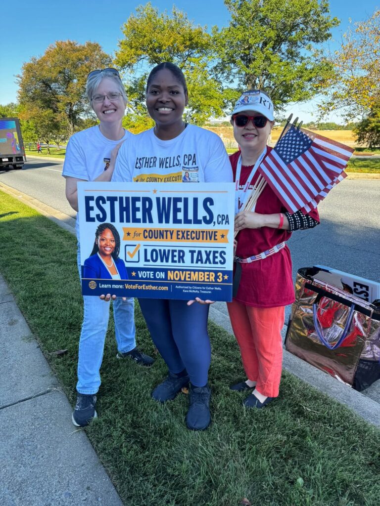 Campaign volunteers holding Esther Wells signs