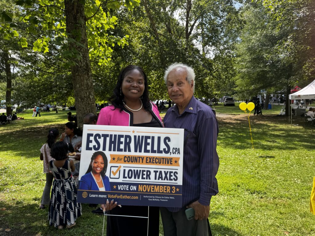 Esther Wells with a supporter holding a Lower Taxes campaign sign
