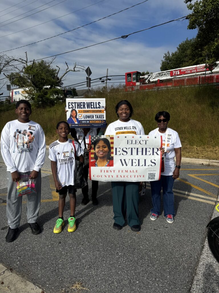 Esther Wells with her mother and her two sons, holding campaign signs in Burtonsville