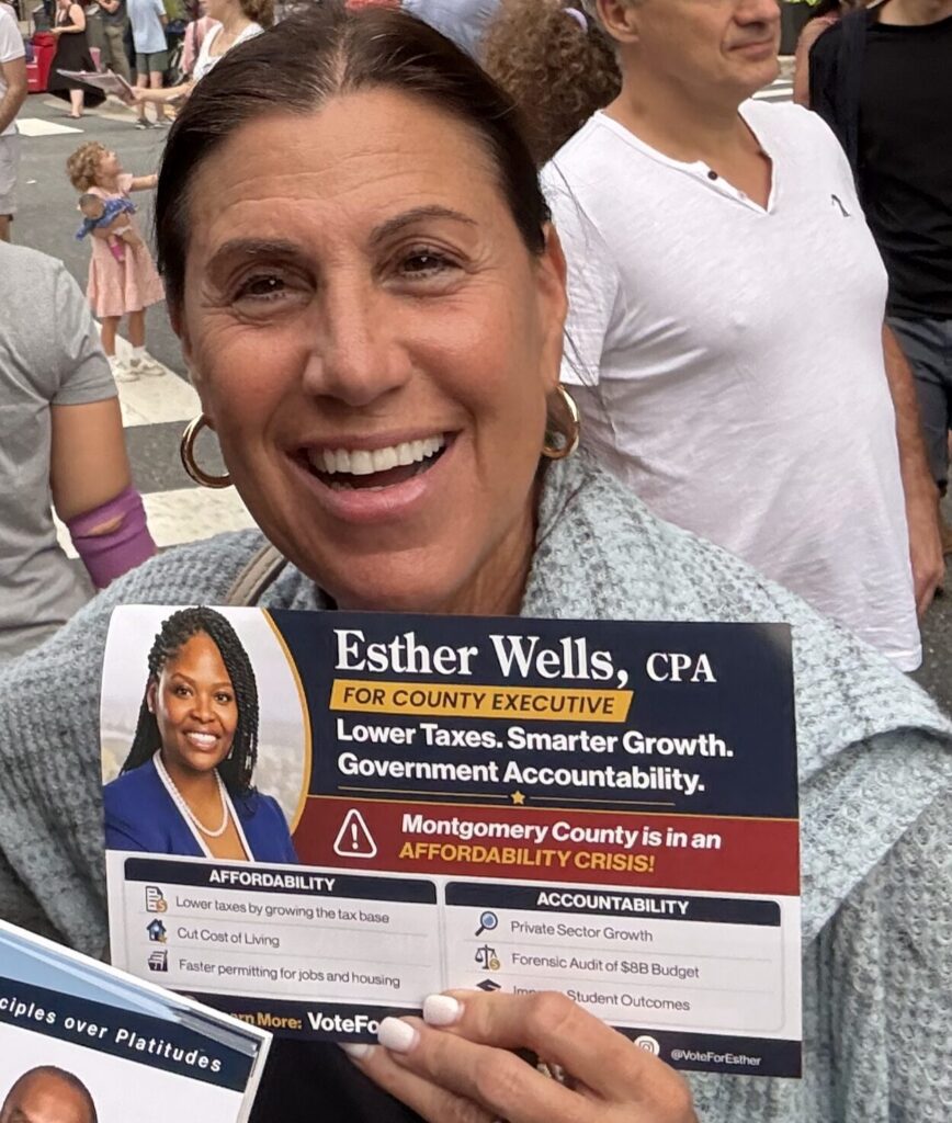 A supporter holding an Esther Wells flyer about the county affordability crisis